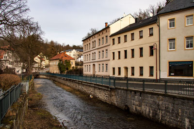 Canal amidst buildings against sky