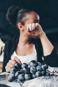 Close-up of woman holding fruit on table