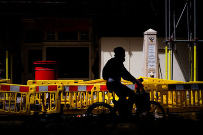 Side view of silhouette man on bike red post box 