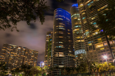 Low angle view of illuminated buildings against sky at night