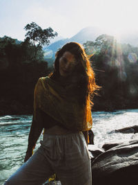 Woman standing by sea against sky