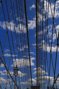 Low angle view of bridge suspension lines against sky