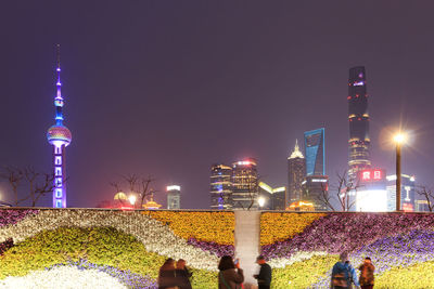 People against illuminated skyscrapers