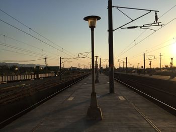 Railroad track against sky during sunset