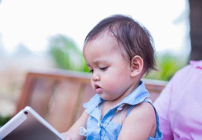 Portrait of cute girl using mobile phone outdoors