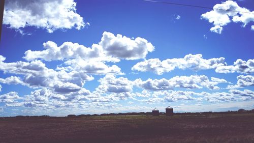 Scenic view of field against cloudy sky