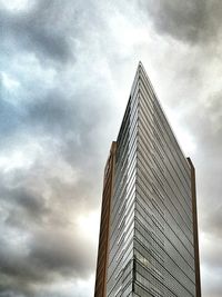 Low angle view of modern buildings against cloudy sky
