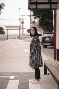 Portrait of young woman standing in city