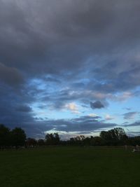 Scenic view of grassy field against cloudy sky