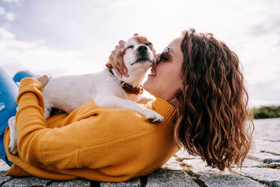 Woman lying down on floor with dog outdoors