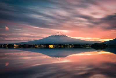 Scenic view of lake and mt fuji against cloudy sky during sunset