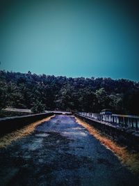 Empty road against clear blue sky