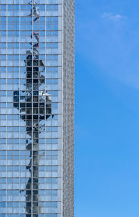 Low angle view of modern buildings against blue sky