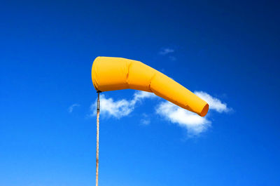 Low angle view of yellow pole against clear blue sky