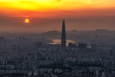 Aerial view of buildings in city during sunset