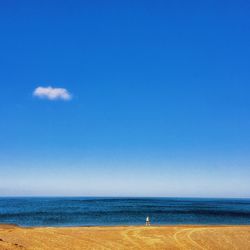 Scenic view of beach against blue sky