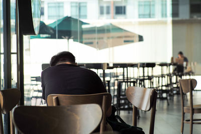 Rear view of man sitting in cafe