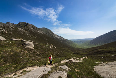 Man walking on mountain against sky