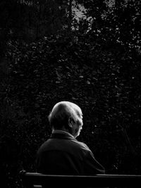 Rear view of man sitting in forest