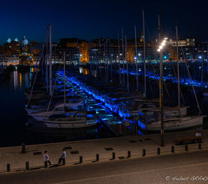 Boats moored at harbor against sky at night