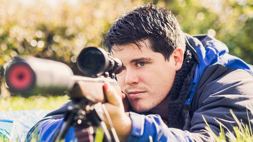 Young man aiming rifle