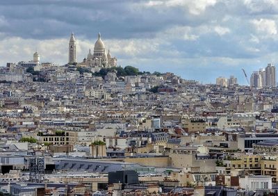 View of cityscape against cloudy sky