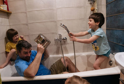 Father and children playing in a bath