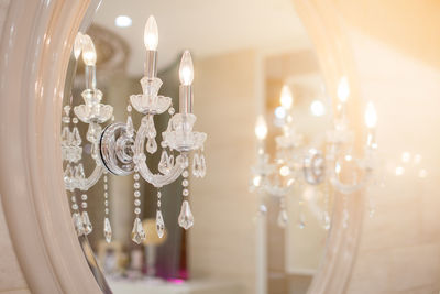 Close-up of illuminated pendant lights hanging from ceiling at home