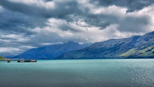 Scenic view of sea and mountains against sky