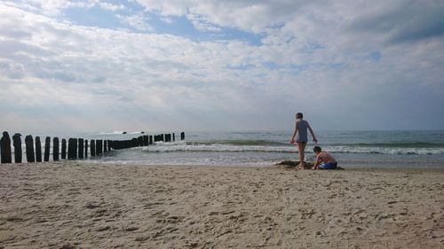 People on beach against sky