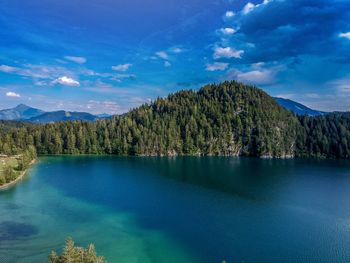 Scenic view from above of lake by trees against blue sky