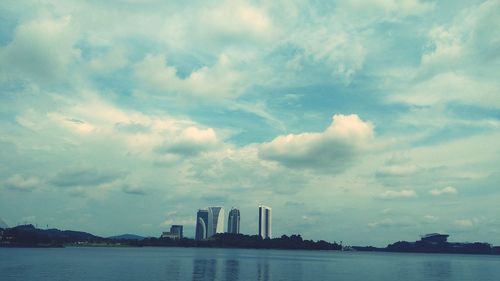 View of buildings in city against cloudy sky