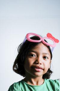 Close-up portrait of cute girl against white background