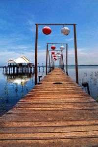 Wooden pier over sea against sky