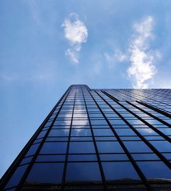 Low angle view of glass building against sky