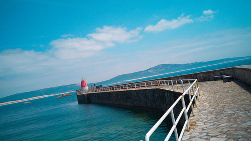 Pier leading to calm blue sea