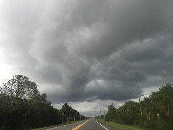 Empty road against cloudy sky