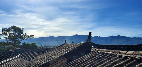 Panoramic view of roof and mountains against sky
