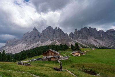 Houses on field by mountains against sky