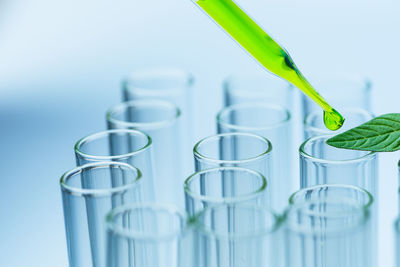 Close-up of green liquid dripping in test tube at laboratory