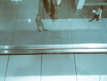 Low section of woman walking on tiled floor