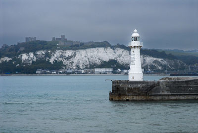 Lighthouse by sea against sky and dover castle