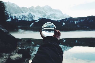 Rear view of man holding ice cream against mountains