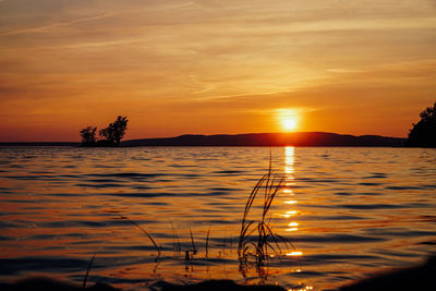 Scenic view of lake against romantic sky at sunset