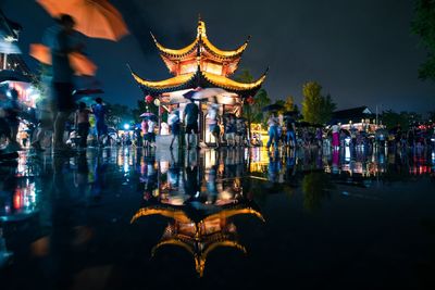 Reflection of illuminated building in lake at night