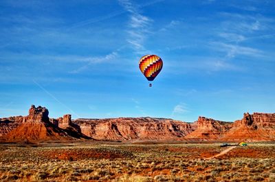 Hot air balloons on rock formation against sky