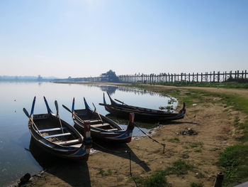 Boat moored on beach against clear sky