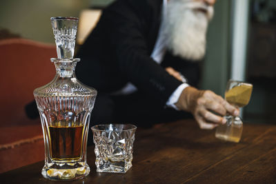 Close-up of man holding drink on table