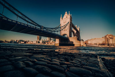 Low angle view of bridge against clear sky in city during sunset