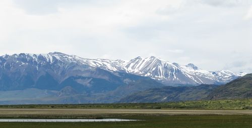 Scenic view of snowcapped mountains against cloudy sky